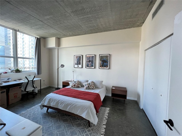 133 NE 2nd Ave Unit 913, Miami, FL 33132 - bedroom featuring finished concrete flooring, baseboards, and a closet