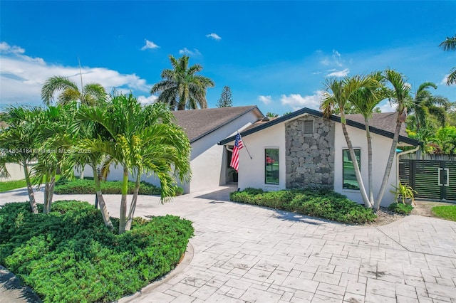 14680 SW 107th Ter, Miami, FL 33186 - view of front of property with stucco siding, stone siding, and curved driveway