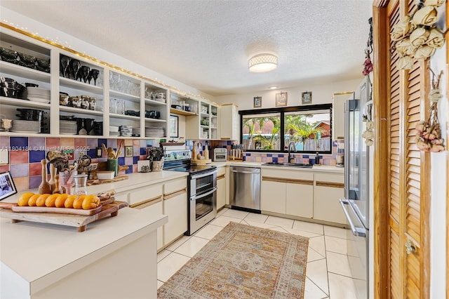 14680 SW 107th Ter, Miami, FL 33186 - kitchen with stainless steel appliances, a sink, light countertops, a textured ceiling, and light tile patterned flooring