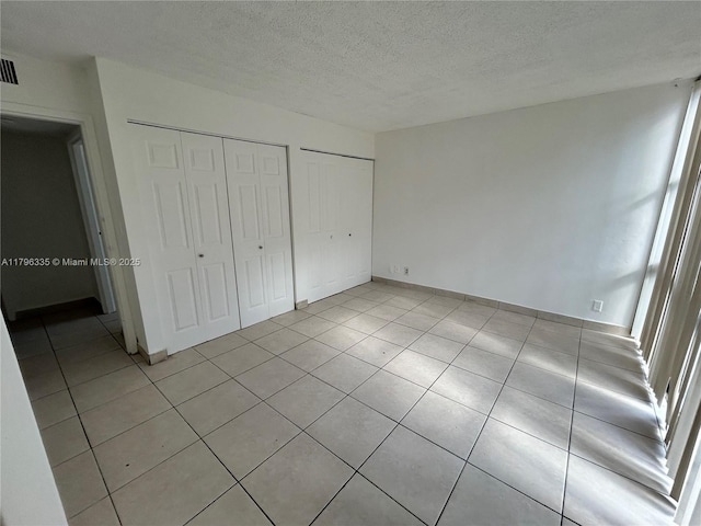 17021 N Bay Rd Unit 329, Sunny Isles Beach, FL 33160 - unfurnished bedroom with light tile patterned floors, a textured ceiling, and two closets