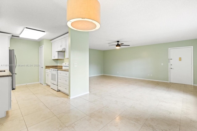 20 Lake Vista Trl Unit 107, Port St Lucie, FL 34952 - kitchen with white range with electric stovetop, under cabinet range hood, freestanding refrigerator, white cabinetry, and ceiling fan