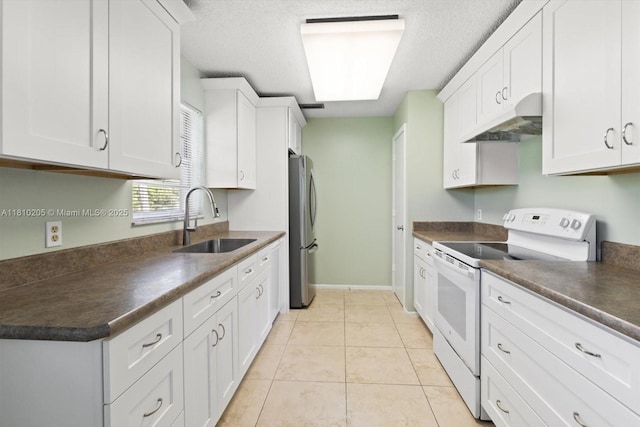 20 Lake Vista Trl Unit 107, Port St Lucie, FL 34952 - kitchen with electric stove, under cabinet range hood, a sink, freestanding refrigerator, and dark countertops