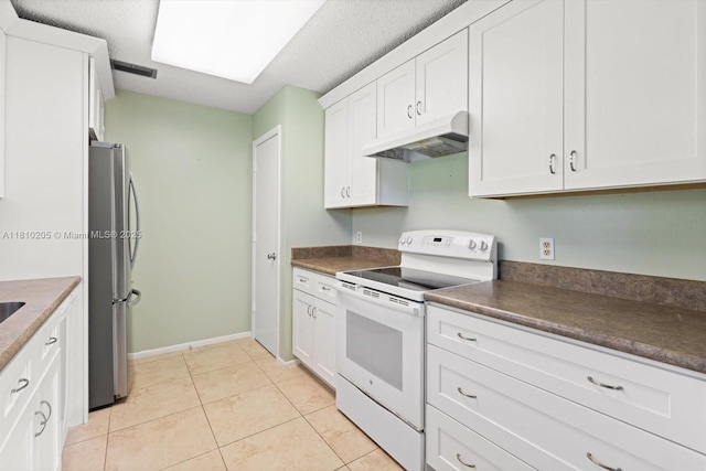 20 Lake Vista Trl Unit 107, Port St Lucie, FL 34952 - kitchen with under cabinet range hood, white electric range oven, freestanding refrigerator, dark countertops, and white cabinets