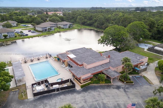 20 Lake Vista Trl Unit 107, Port St Lucie, FL 34952 - drone / aerial view of a pool area, a nearby body of water, and a heavily wooded area