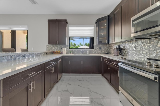 21305 SW 177th Ct, Miami, FL 33187 - kitchen featuring appliances with stainless steel finishes, light marble finish floors, tasteful backsplash, glass insert cabinets, and dark brown cabinets