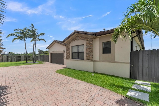 21305 SW 177th Ct, Miami, FL 33187 - view of front of property with stucco siding, decorative driveway, an attached garage, and stone siding