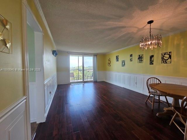 900 Colony Point Cir Unit 505, Pembroke Pines, FL 33026 - dining room featuring ornamental molding, wainscoting, a chandelier, a textured ceiling, and wood finished floors