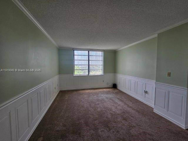 900 Colony Point Cir Unit 505, Pembroke Pines, FL 33026 - carpeted empty room featuring crown molding, a textured ceiling, a wainscoted wall, and a decorative wall