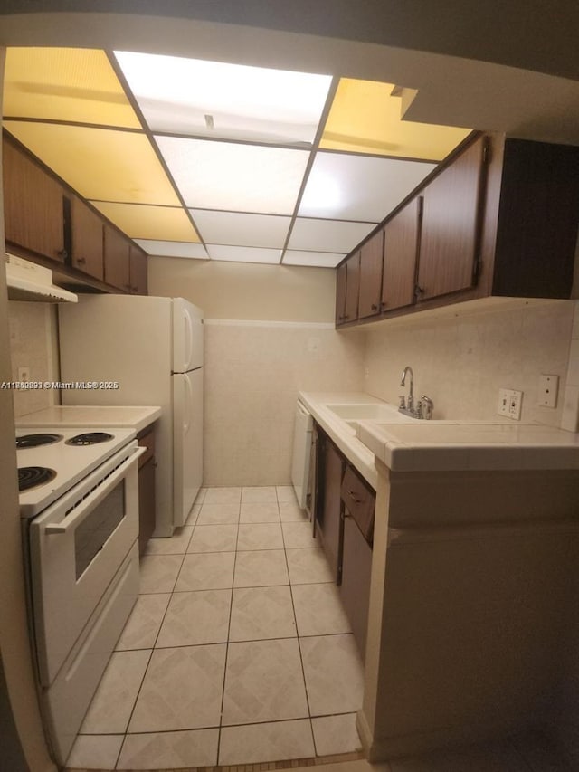 1500 N Congress Ave Unit B53, West Palm Beach, FL 33401 - kitchen featuring white electric stove, under cabinet range hood, a sink, light countertops, and light tile patterned floors