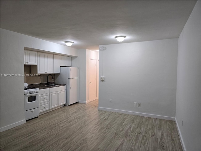 1140 71st St Unit 3, Miami Beach, FL 33141 - kitchen with white appliances, light wood-style floors, baseboards, and white cabinets
