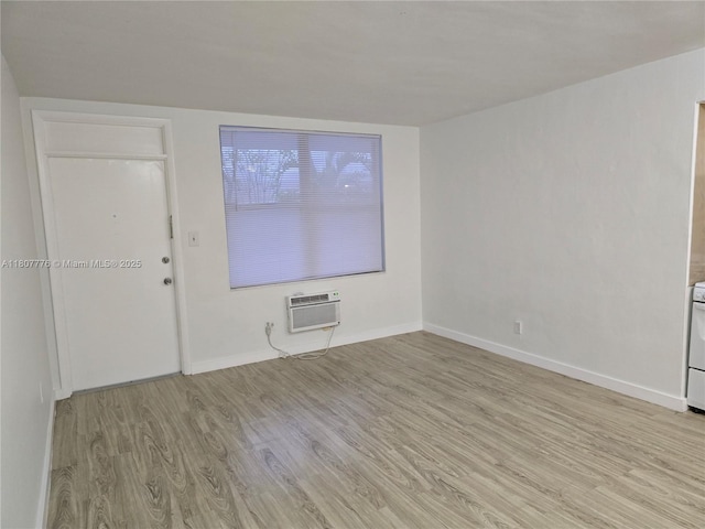 1140 71st St Unit 3, Miami Beach, FL 33141 - unfurnished room with a wall mounted air conditioner, light wood-type flooring, and baseboards