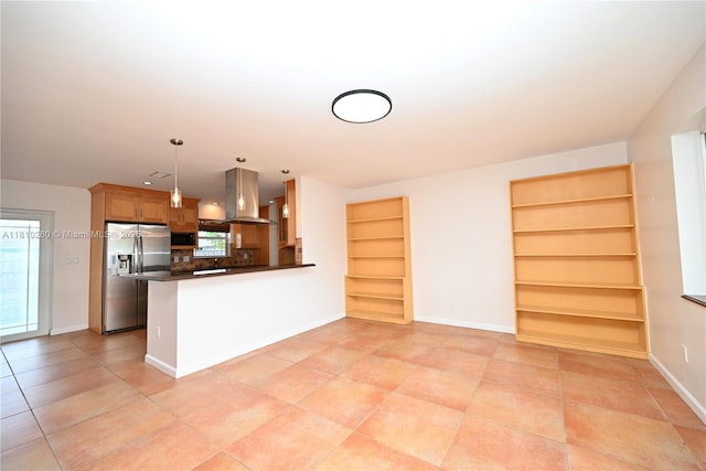 16320 SW 100th Ct, Miami, FL 33157 - kitchen featuring stainless steel refrigerator with ice dispenser, wall chimney range hood, dark countertops, a peninsula, and built in features