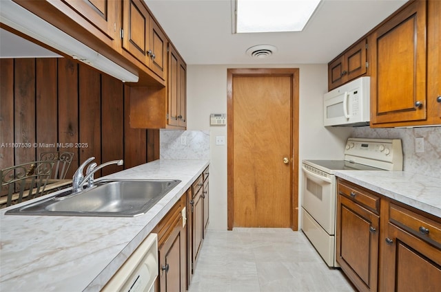 4465 SW 37th Ave, Dania Beach, FL 33312 - kitchen featuring white appliances, a sink, tasteful backsplash, light countertops, and brown cabinetry