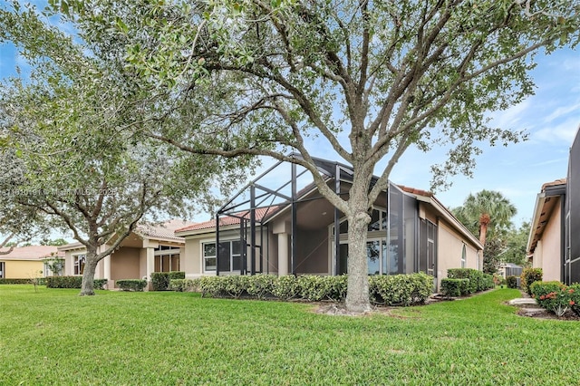 9212 Short Chip Cir, Port St Lucie, FL 34986 - rear view of property featuring stucco siding, a yard, glass enclosure, and a tiled roof
