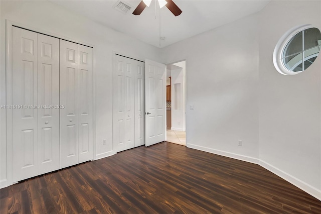 9212 Short Chip Cir, Port St Lucie, FL 34986 - unfurnished bedroom featuring multiple closets, baseboards, dark wood-type flooring, and a ceiling fan