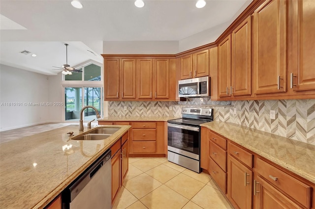 9212 Short Chip Cir, Port St Lucie, FL 34986 - kitchen featuring appliances with stainless steel finishes, a sink, light stone countertops, tasteful backsplash, and brown cabinetry