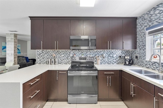 18110 SW 153rd Ct, Miami, FL 33187 - kitchen with appliances with stainless steel finishes, a peninsula, dark brown cabinetry, and backsplash