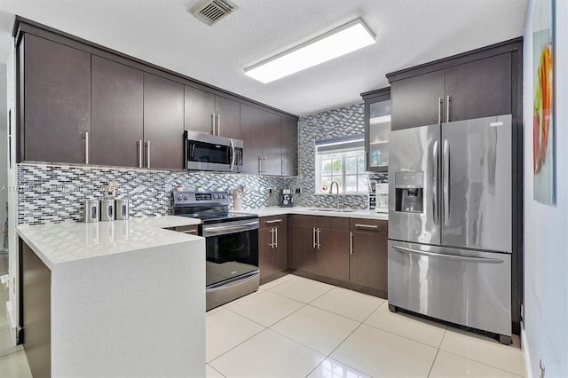 18110 SW 153rd Ct, Miami, FL 33187 - kitchen with stainless steel appliances, light countertops, dark brown cabinetry, decorative backsplash, and light tile patterned floors