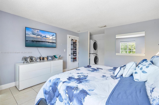 18110 SW 153rd Ct, Miami, FL 33187 - bedroom featuring stacked washer / drying machine, a textured ceiling, tile patterned flooring, and a closet