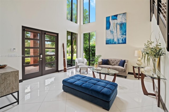 9145 NW 154th Ter, Miami Lakes, FL 33018 - living area with french doors, tile patterned floors, a towering ceiling, and baseboards