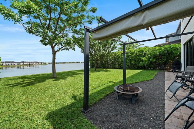 9145 NW 154th Ter, Miami Lakes, FL 33018 - view of green lawn featuring an outdoor fire pit, a water view, and a patio