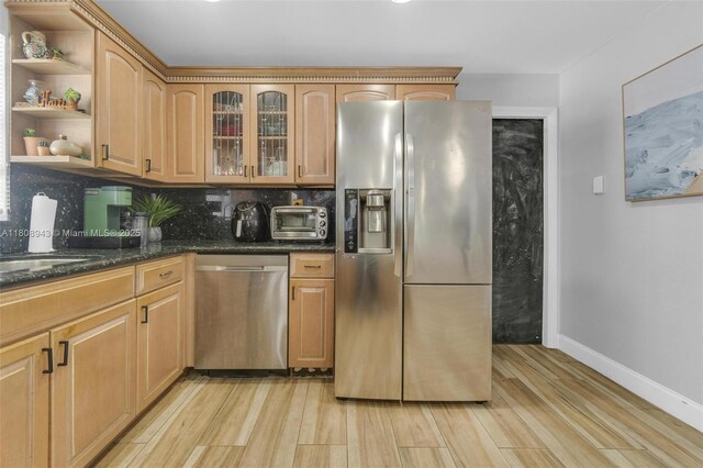2412 Raleigh St, Hollywood, FL 33020 - kitchen with appliances with stainless steel finishes, light wood-type flooring, decorative backsplash, open shelves, and dark stone counters