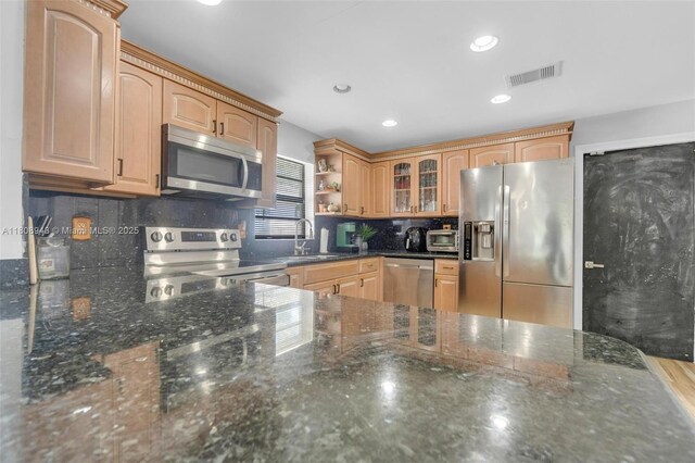 2412 Raleigh St, Hollywood, FL 33020 - kitchen featuring appliances with stainless steel finishes, a sink, glass insert cabinets, open shelves, and dark stone counters
