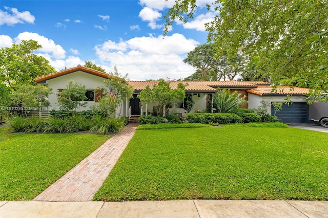 259 E Shore Dr E, Miami, FL 33133 - mediterranean / spanish house with a tile roof, a front lawn, an attached garage, and stucco siding