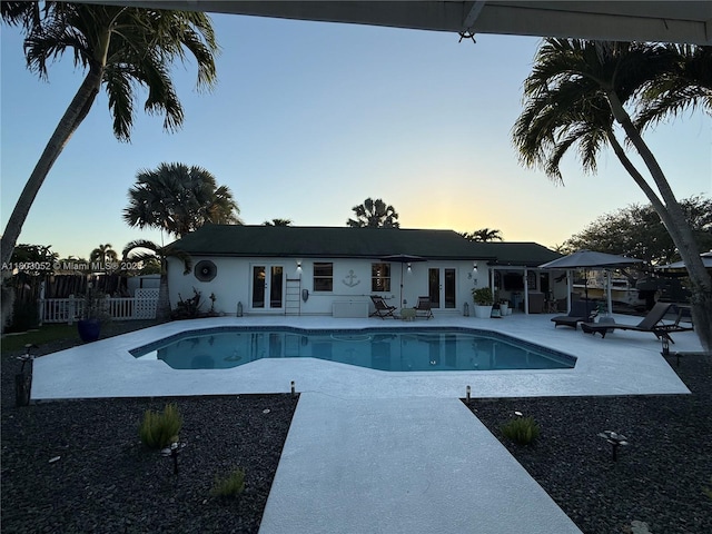 15223 SW 152nd Ave, Miami, FL 33187 - pool at dusk featuring a patio area, french doors, and an outdoor pool