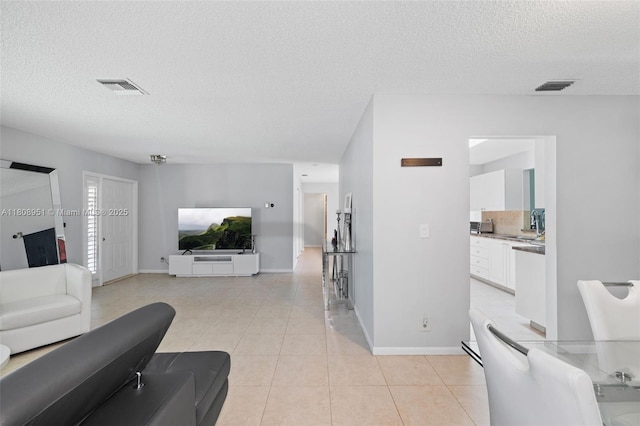 2394 NW 7th Ct, Delray Beach, FL 33445 - living room with a textured ceiling, light tile patterned floors, and baseboards