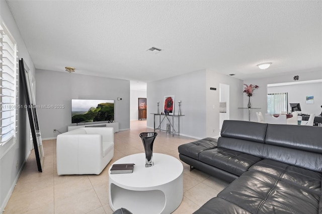 2394 NW 7th Ct, Delray Beach, FL 33445 - living area with light tile patterned flooring, baseboards, and a textured ceiling