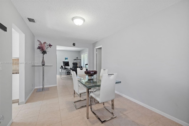 2394 NW 7th Ct, Delray Beach, FL 33445 - dining space with a textured ceiling, baseboards, and light tile patterned floors
