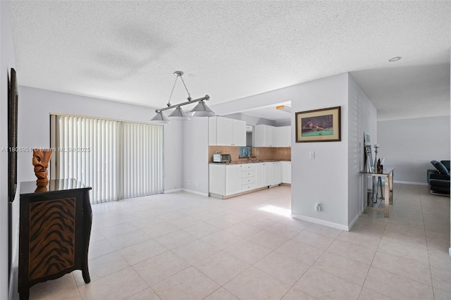 2394 NW 7th Ct, Delray Beach, FL 33445 - living room featuring a textured ceiling, light tile patterned floors, and baseboards