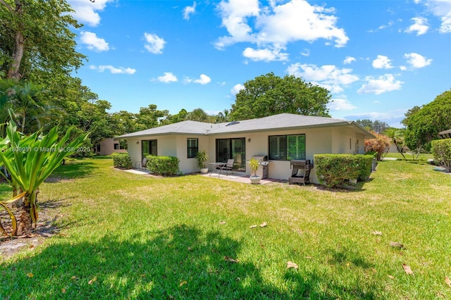 2394 NW 7th Ct, Delray Beach, FL 33445 - rear view of house featuring a patio, a yard, and stucco siding