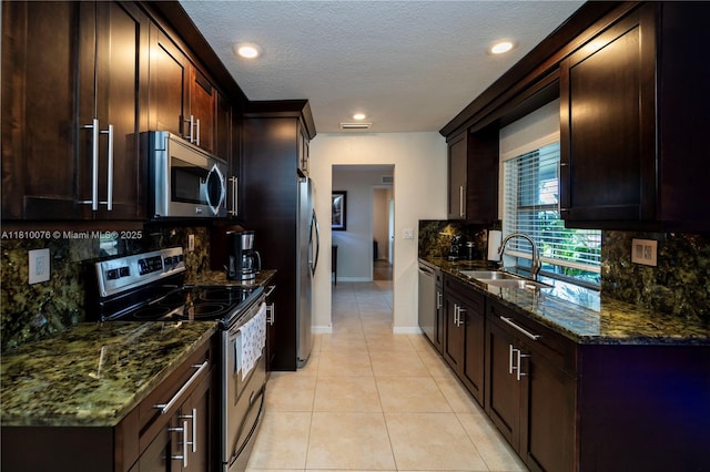 5710 NW 73rd Ave, Tamarac, FL 33321 - kitchen with stainless steel appliances, a sink, light tile patterned flooring, dark stone counters, and backsplash
