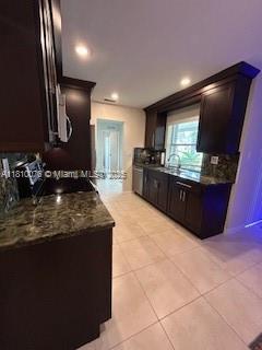5710 NW 73rd Ave, Tamarac, FL 33321 - kitchen featuring light tile patterned floors, dark stone countertops, and recessed lighting