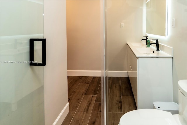 5710 NW 73rd Ave, Tamarac, FL 33321 - bathroom featuring toilet, wood finish floors, vanity, and baseboards