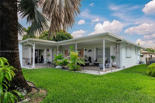 5710 NW 73rd Ave, Tamarac, FL 33321 - rear view of house with a lawn, a patio, and stucco siding