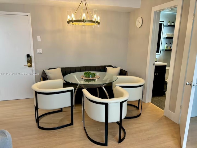 750 Collins Ave Unit 206, Miami Beach, FL 33139 - dining room featuring a chandelier and light wood-style floors