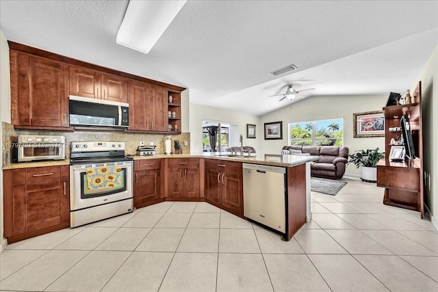 18018 SW 30th Ct, Miramar, FL 33029 - kitchen with stainless steel appliances, a ceiling fan, lofted ceiling, backsplash, and a peninsula