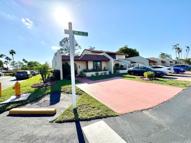 18830 NW 65th Ct, Hialeah, FL 33015 - view of front of home featuring a tile roof, stucco siding, a front yard, and uncovered parking