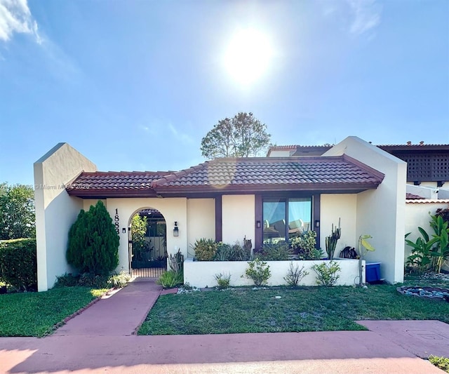 18830 NW 65th Ct, Hialeah, FL 33015 - mediterranean / spanish home with a tiled roof, stucco siding, and a front lawn