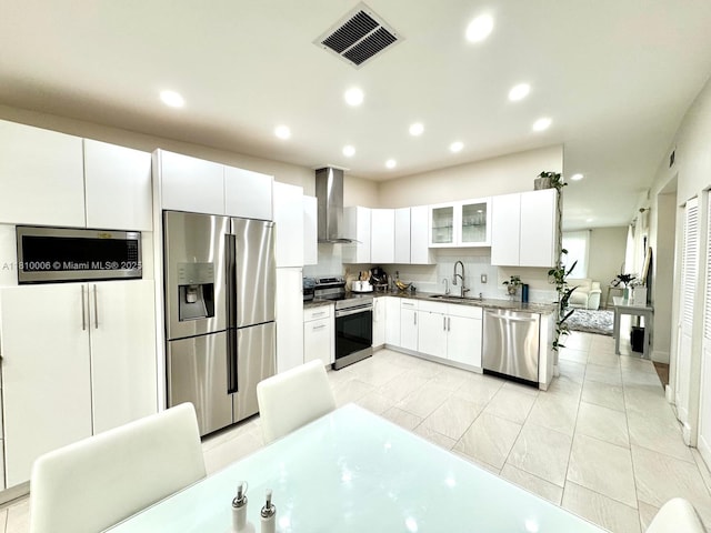 18830 NW 65th Ct, Hialeah, FL 33015 - kitchen featuring stainless steel appliances, wall chimney range hood, recessed lighting, white cabinets, and a sink