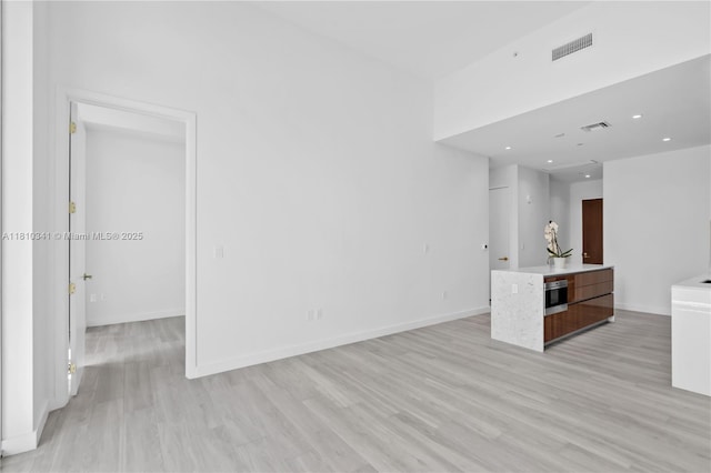 2655 S Bayshore Dr Unit 705, Miami, FL 33133 - unfurnished living room featuring light wood-type flooring, baseboards, and recessed lighting