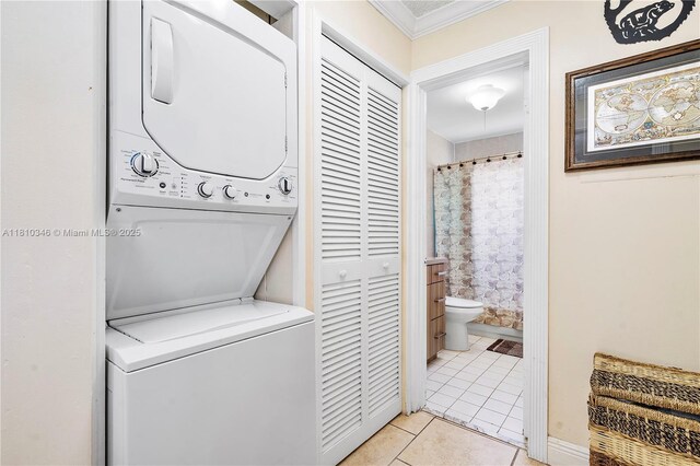 5829 Taylor St, Hollywood, FL 33021 - laundry area featuring stacked washer / dryer, light tile patterned floors, and ornamental molding