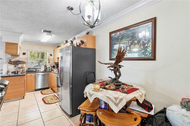 5829 Taylor St, Hollywood, FL 33021 - kitchen with stainless steel appliances, crown molding, a textured ceiling, dark countertops, and light tile patterned floors