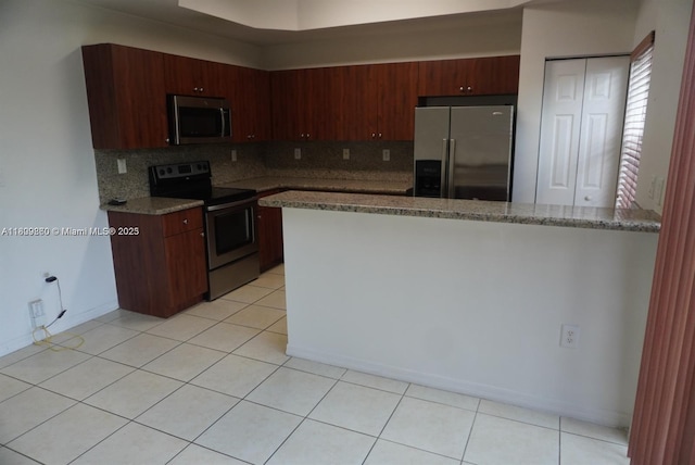 1083 SW 143rd Ave Unit 1206, Pembroke Pines, FL 33027 - kitchen with stainless steel appliances, backsplash, a peninsula, and light tile patterned floors