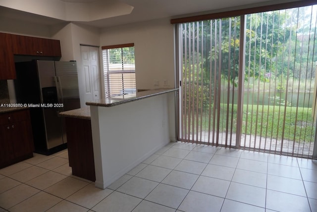 1083 SW 143rd Ave Unit 1206, Pembroke Pines, FL 33027 - kitchen featuring stainless steel fridge, light tile patterned floors, light stone countertops, and a peninsula