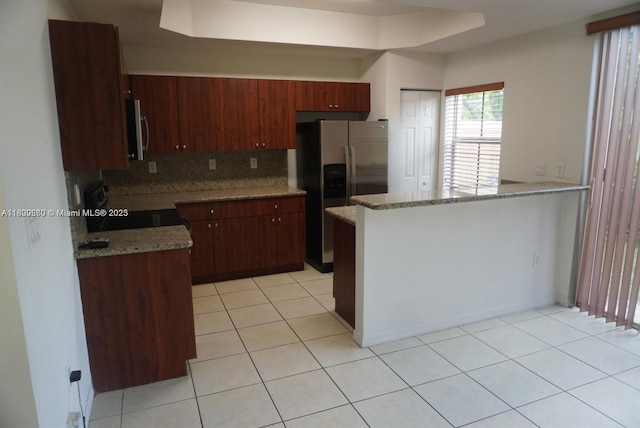 1083 SW 143rd Ave Unit 1206, Pembroke Pines, FL 33027 - kitchen with stainless steel appliances, backsplash, light tile patterned floors, a peninsula, and light stone countertops