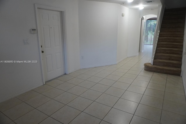 1083 SW 143rd Ave Unit 1206, Pembroke Pines, FL 33027 - unfurnished room with arched walkways, light tile patterned flooring, stairway, and baseboards